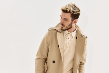 man with fashionable hairstyle beige coat side glance glamor clothing