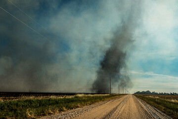 A landscape shot of a dust devil, wind whirl, or dust whirl of dust swirling in a swirl over power...