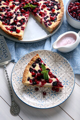 Piece of delicious currant pie served on white wooden table