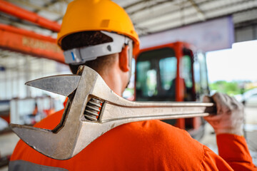Close-up photo of tractor mechanic Hold a large spanner or an adjustable wrench. used for large vehicles Auto parts and tools, wrenches and heavy-duty equipment in the garage. © เลิศลักษณ์ ทิพชัย