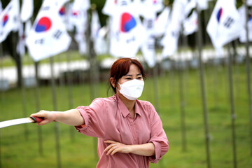 Korean woman practicing kendo in a hi-dong kendo pose with a sword