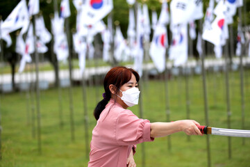 Korean woman practicing kendo in a hi-dong kendo pose with a sword