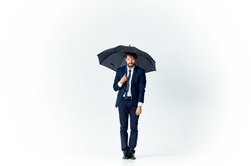 man in a suit with an umbrella in his hands protection from the rain elegant style full length