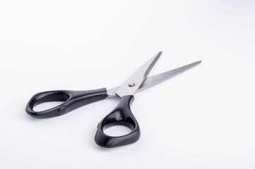 open scissors with black handle on white background side view