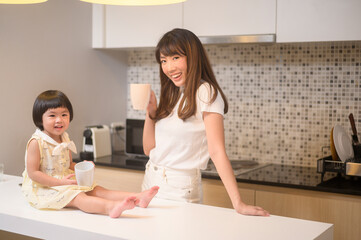 Portrait of happy mom and daughter in kitchen at home
