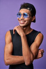Portrait of cheerful transgender male in black t-shirt, blue sunglasses. Latin american trans gender