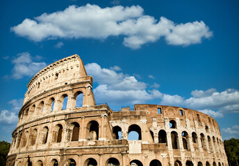 Obraz premium Rome, Italy. Arches archictecture of Colosseum exterior with blue sky background and clouds.