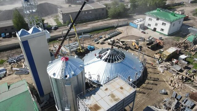 Aerial view Flight over the large construction of the agricultural complex. Construction site. Construction of premises for storage and processing of grain and storage and production of biogas.