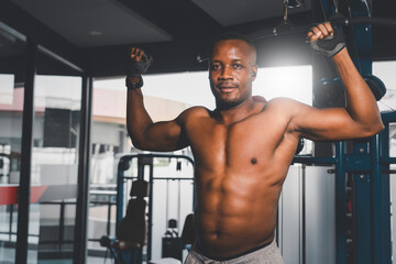 Fototapeta na wymiar Portrait of Black muscular male athlete workout in fitness gym