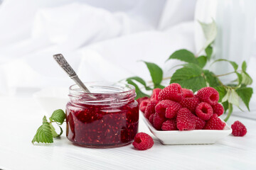 Jar of raspberry jam and fresh berries.