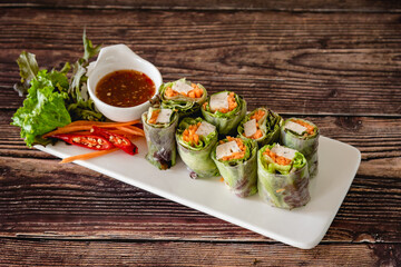 Closed up fresh Asian spring rolls as portion stuff vegetable, pork inside noodle tubes with spicy sauce, healthy food