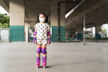 Asian child cute or kid girl exercise playing pink rollerblade or inline skates on sport skating...
