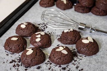 Homemade Chocolate Brownie cookies and almond slide on with papers for baking