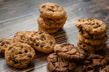 Delicious of stacked chocolate chips cookies on white napkin at wooden table