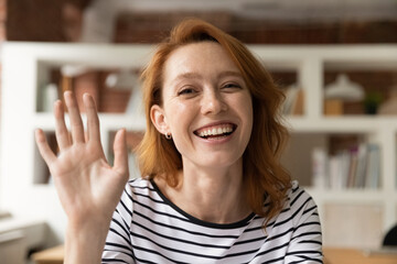 Head shot happy young woman greeting friend talks to webcam participate in videoconference negotiate to client using app, modern tech, internet connection. Video call event for work and study concept