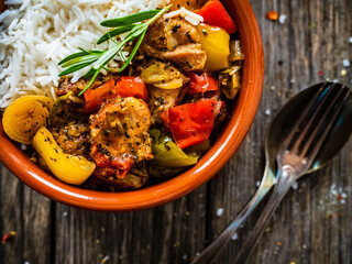 Roast pork with jasmine rice and vegetables in bowl on wooden table

