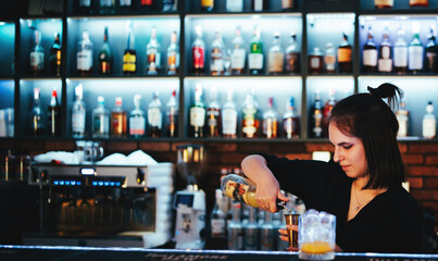 Portrait of young attractive woman bartender Making Cocktail in bar