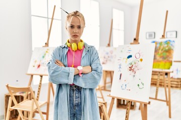 Young caucasian girl at art studio skeptic and nervous, disapproving expression on face with...