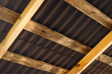 Brown ondulin roof background. The construction of the wooden roof. Detailed photo of a wooden roof overlap construction