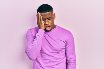 Obraz premium Young black man wearing casual pink sweater yawning tired covering half face, eye and mouth with hand. face hurts in pain.