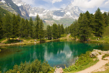 Naklejka na ściany i meble View of idyllic emerald alpine lake with matterhorn massif in the background in Valle d'Aosta, Italy