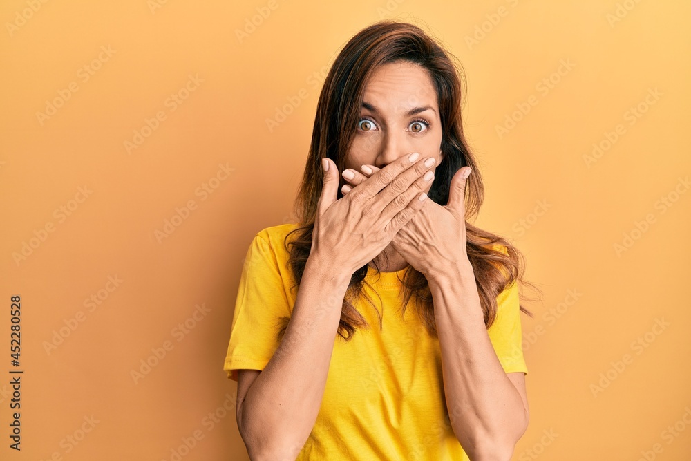 Canvas Prints Young latin woman wearing casual clothes shocked covering mouth with hands for mistake. secret concept.