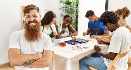 Fototapeta premium Group of people drawing sitting on the table. Caucasian man smiling happy looking to the camera at art studio.