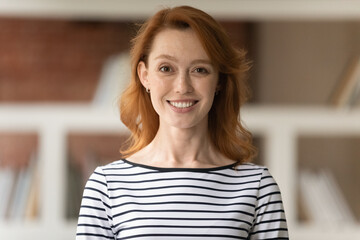 Head shot portrait of smiling professional female advisor, business trainer, businesslady coach looking at camera pose in office. New company employee photoshoot, hired worker profile picture concept