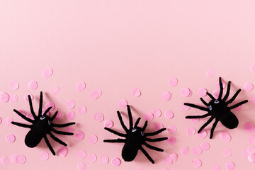 Halloween card with black spiders and confetti on pink background