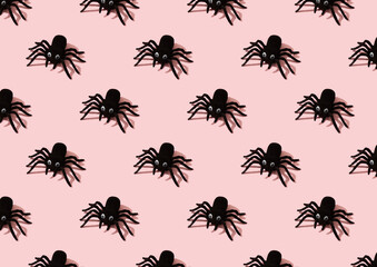 Seamless pattern with black toy spiders on pink background