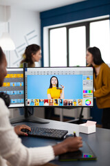 Black retoucher artist analysing images on pc with two monitors and retouching digital assets with...