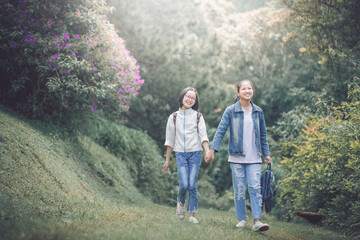 Fototapeta na wymiar Cute two asian lovely cheerful student girls walking in park