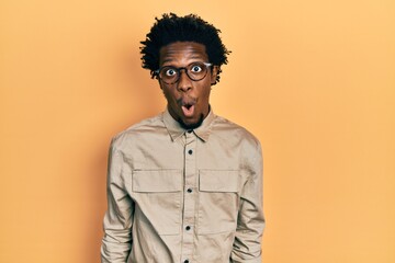 Young african american man wearing casual clothes and glasses afraid and shocked with surprise expression, fear and excited face.