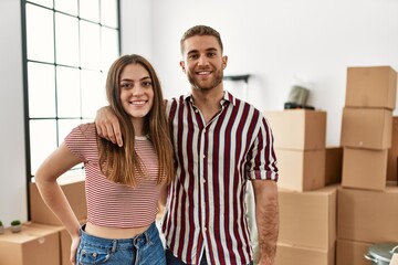 Young caucasian couple smiling happy at new home.