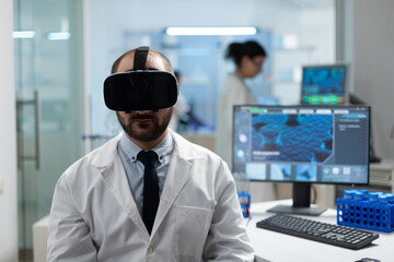 Chemist researcher analyzing sickness development using virtual reality headset during medical experiment in biochemistry hospital laboratory. Modern biotechnology equipment