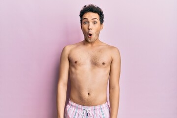 Fototapeta premium Young handsome man wearing swimwear shirtless afraid and shocked with surprise expression, fear and excited face.