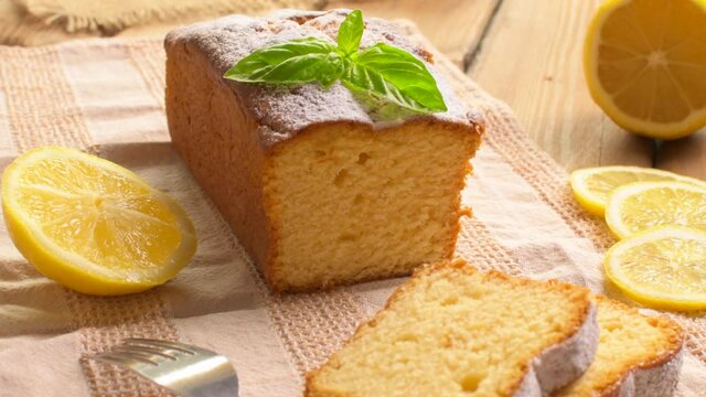 Lemon pound cake on rustic wooden background with lemon and mint.