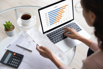Woman prepare report, makes expenses statistics, above close up view. Financial expert viewing...