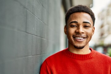 Handsome african american man outdoors standing over gray wall