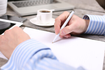 business, education, people and technology concept - male hands with laptop computer, notebook and pen taking notes