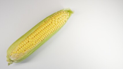 Fresh corn on the cob on a white surface