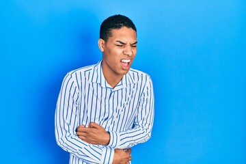 Young african american guy wearing casual clothes with hand on stomach because nausea, painful...