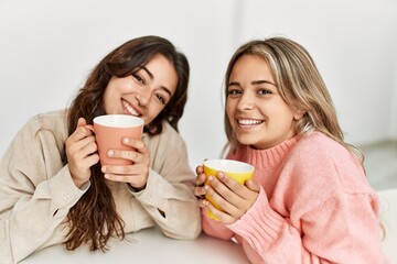 Young beautiful couple smiling happy drinking coffee at home.