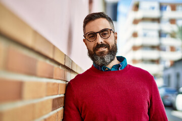 Young hispanic executive man smiling happy standing at the city.
