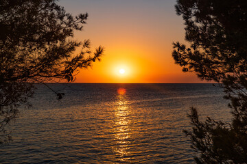 Naklejka na ściany i meble Sunset over Adriatic sea horizon, colorful red sky, island of Dugi Otok, Croatia