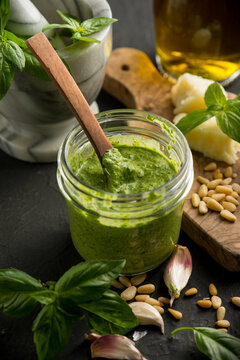 traditional italian pesto with ingredients over black background