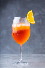 Cocktail aperol spritz. Glass of cocktail aperol spritz on a gray background. Italian summer cocktail with a slice of orange