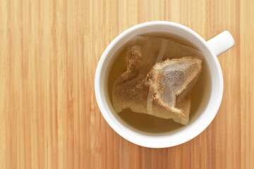 Tea bag in a tea cup. Healthy herbal tea in a mug. Flat lay top view photo.  Food from above...