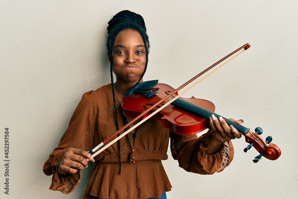 Sticker african american woman with braided hair playing violin puffing cheeks with funny face. mouth inflat