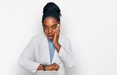 Young african american woman wearing business clothes looking at the watch time worried, afraid of getting late